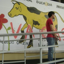 Rogelio Orizondo in front of the advertisement for the theatrical production, Vacas